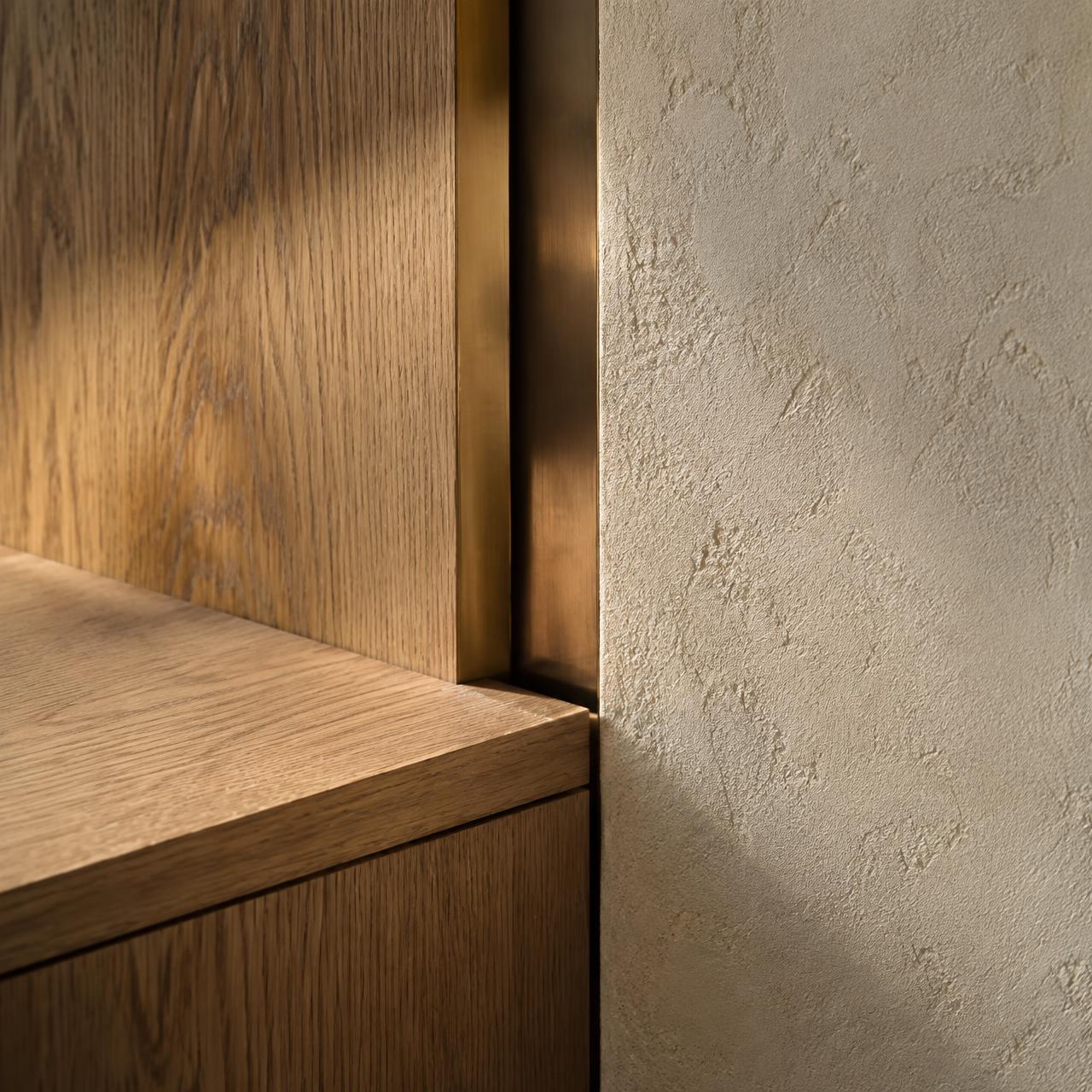 Close detail of oak joinery and bronze reveal